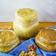 Three jars of different types of walnut butter: honey cinnamon, regular, and cacao.