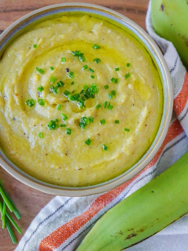 Bowl of mashed plantains with plantains on the side.