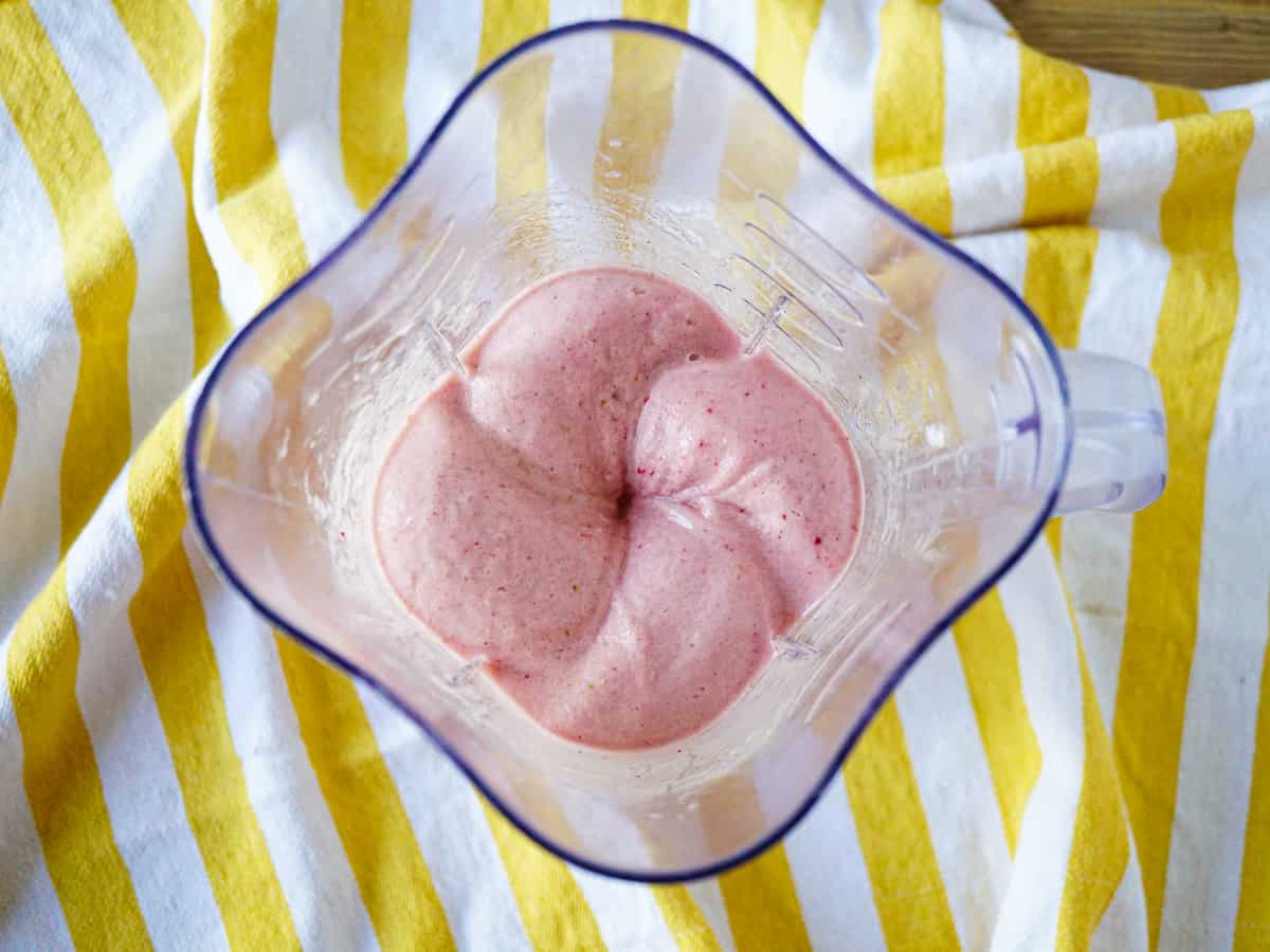 Top view of strawberry smoothie in a blender.